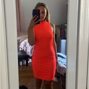 Neon turtleneck dress with cutouts along the side.